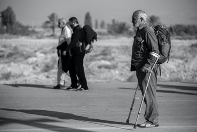 拄着拐杖的男人的灰度照片